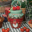 A decorative picnic-style bag filled with jars of strawberry jam, topped with two crocheted strawberries and a green-and-white checkered handle. The front of the basket has a red zipper, a strawberry print, and a label reading "Strawberry jam.