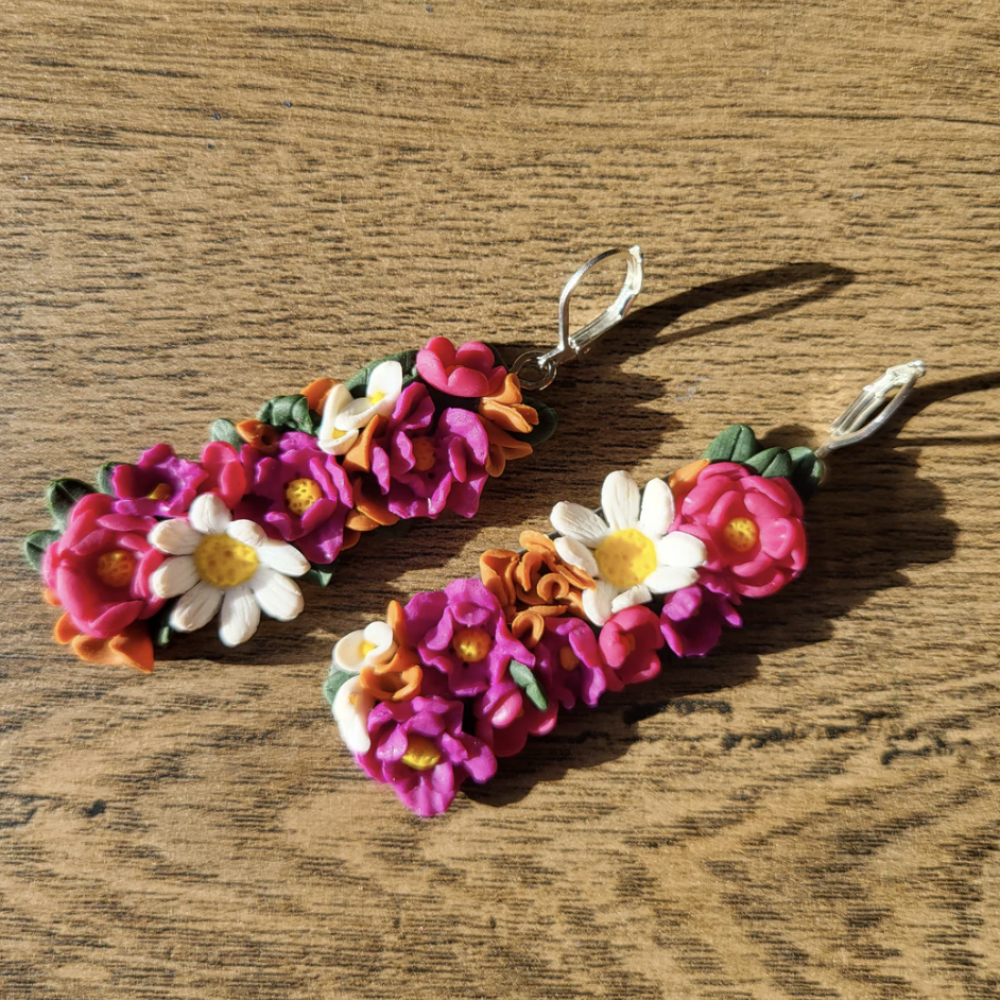 Colorful floral earrings on a wooden surface