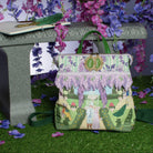 Handbag with garden design on a grassy surface with flowers in the background
