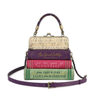 A handbag designed to look like a stack of four vintage handbag books, with a purple leather top handle and a matching adjustable shoulder strap. The book spines are cream, purple, pink, and green, with gold and white lettering.