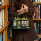 Person holding a decorative bag in front of a bookshelf filled with books.